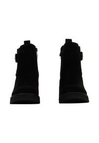 Bottines en daim noir avec un bout arrondi, des zips latéraux et une semelle épaisse et texturée. Dotées d'un petit accent en boucle sur le côté extérieur.