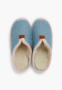 Niebieskie kapcie w wzór rybiej ości z miękkim kremowym wykończeniem, różowym obszyciem i brązową metką z przodu. Okrągłe czubki i fason wsuwany.