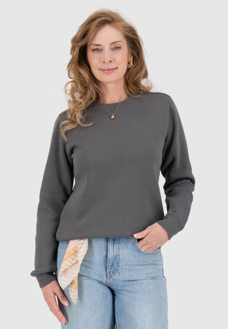 Grijze sweatshirt met lange mouwen, ronde hals en geribbelde boorden. Draag met lichtblauwe jeans en een patroon sjaal om de taille geknoopt.