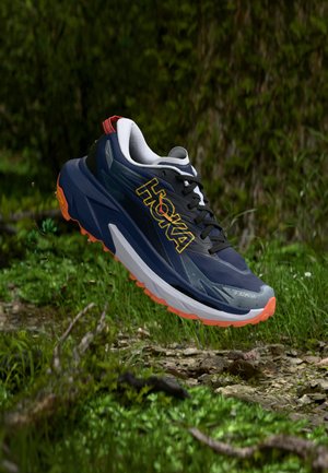 Must ja hall jooksujalats oranžide detailidega, millel on paks tald, tekstureeritud ülaosa ja silmatorkav logo küljel.