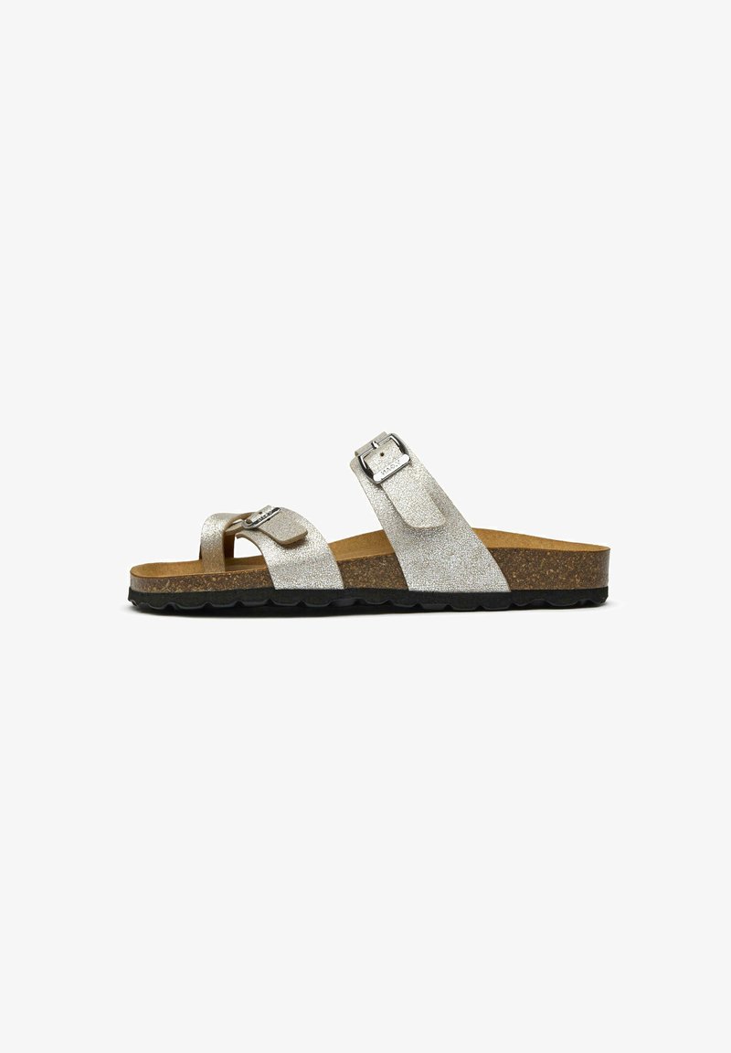 Silver glitter slide sandal with two adjustable straps, cork footbed, and a black textured rubber sole. Minimalistic design, casual style.