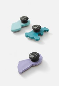 Trois pinces en caoutchouc en teintes teal, turquoise et lavande avec des fermetures noires. Chacune a un design distinct ; surfaces lisses et bords arrondis.