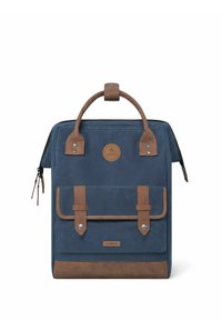 Navy canvas backpack with brown leather accents, featuring a top handle, two front straps, and a zip closure. Logo patch on front.