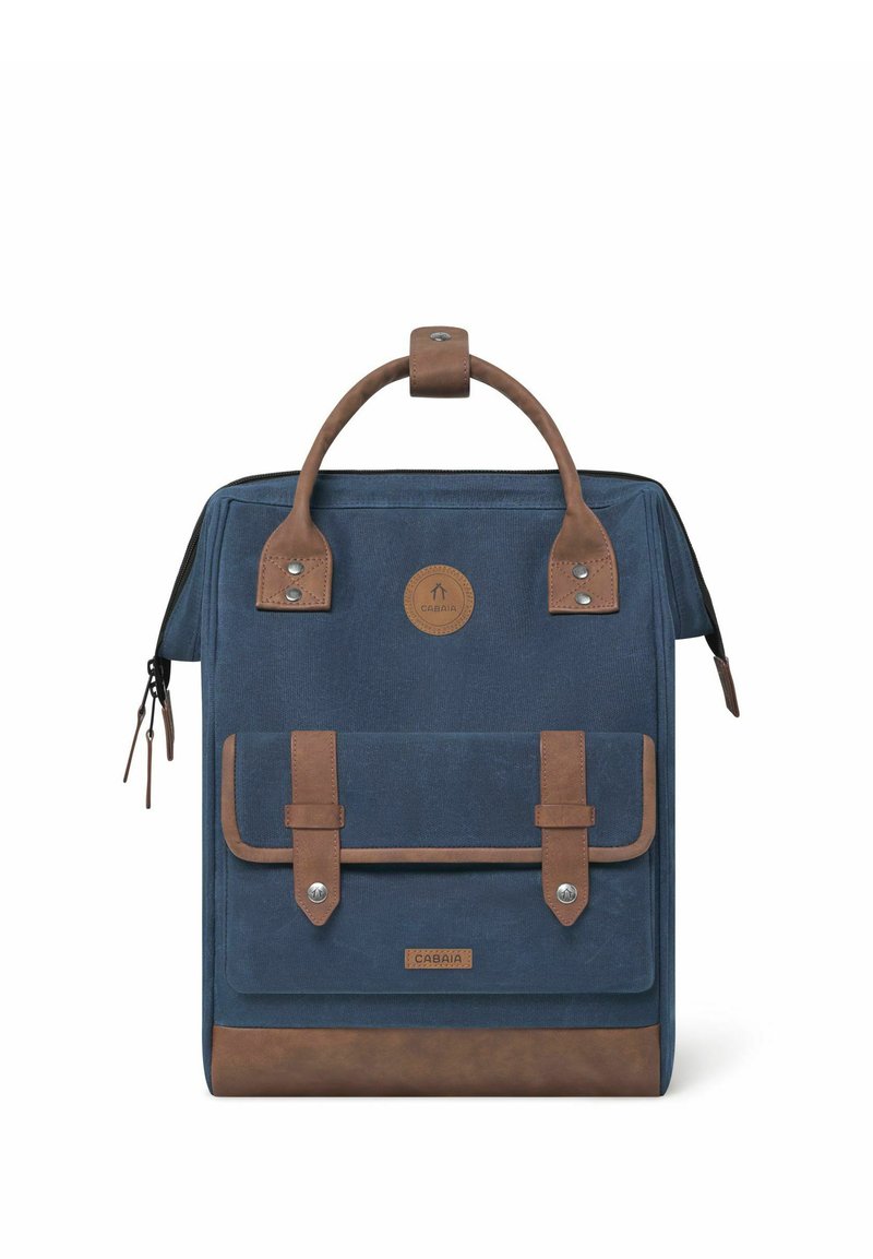 Navy canvas backpack with brown leather accents, featuring a top handle, two front straps, and a zip closure. Logo patch on front.