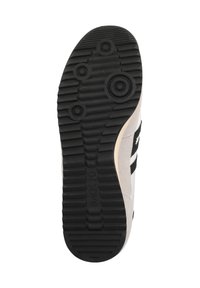 Semelle de chaussure en caoutchouc noir texturé, avec des motifs de traction circulaires, un côté en daim beige et des accents noirs. Présente le marquage "BACK70".