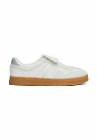 Baskets blanches avec un dessus en cuir lisse, des accents argentés, un laçage et une fermeture à boucle auto-agrippante, et une semelle en caoutchouc gum. Détail de logo subtil sur le côté.