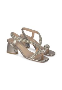 Sandalias metálicas plata con punta cuadrada y tacón bloque. Cuenta con adornos de cristal en las correas para un detalle adicional.