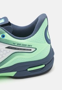 Mizuno Wave Exceed Tour 6 teniso bateliai mėlynai-mėtų spalvų, turintys tekstūruotą viršutinę dalį, tinklinę panelę ir matomą bangos amortizavimo sistemą.