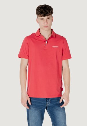 Polo rosso con colletto, patta con due bottoni e maniche corte. Presenta un piccolo logo bianco sul petto e un'etichetta laterale.