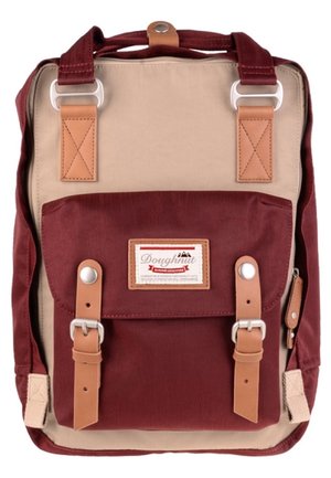 Beige en bordeaux rechthoekige rugzak met klepzak aan de voorkant, lichtbruine gespsbanden, zilverkleurige hardware en Doughnut merklabel op de zak.
