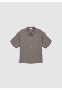 Chemise à manches courtes avec boutons, de couleur taupe, col classique, posée à plat sur un fond gris clair.