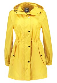 Gele waterdichte regenjas met een trekkoord in de taille, twee voorzakken en een capuchon. Voorzien van drukknoopsluitingen en elastische manchetten.