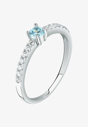 Silberner Ring mit einem hellblauen runden Edelstein in der Mitte und kleinen klaren Diamanten, die auf einer Seite des Rings eingefasst sind.