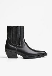 Črne usnjene gležnarske čevlje s koničastim nosom, nizko zloženo peta in elastičnimi stranskimi paneli za enostavno obuvanje.