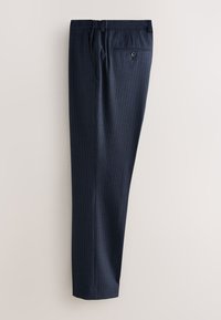 Pantaloni da abito blu navy a righe sottili piegati nel senso della lunghezza con tasca posteriore visibile e bottone su sfondo chiaro.