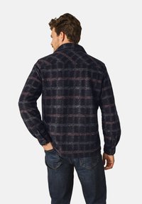 Mannen geruite overhemd, donker marineblauw met kastanjebruine accenten, knoopmanchetten en een licht gestructureerde stof. Kragen en achterste yoke zichtbaar.