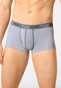Boxer in cotone grigiocon un elastico nero in vita che presenta il marchio "sloggi". Il tessuto ha una texture liscia e un design aderente.