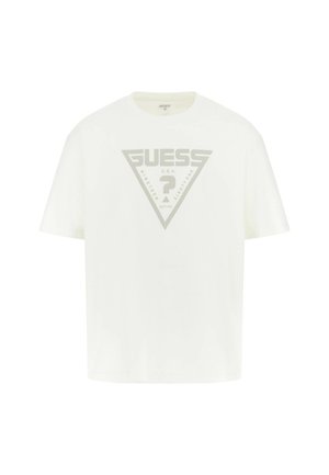 Valge puuvillane t-särk, millel on suur hall kolmnurkne graafika, kus on kirjas "GUESS," "U.S.A." ja "NINETEEN EIGHTY-ONE." Lühikesed varrukad, ümmargune kaelus.