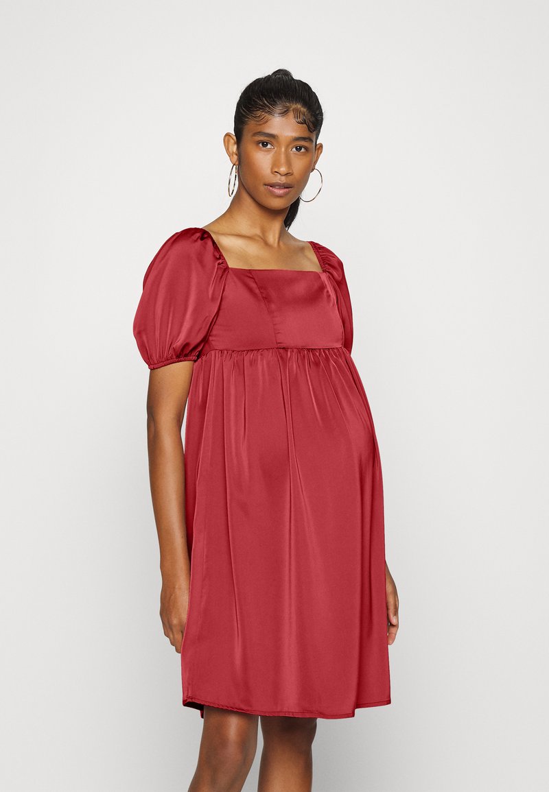 Vestido de cetim vermelho com decote quadrado e mangas bufantes. Corte normal com uma silhueta fluida e detalhes franzidos na cintura.