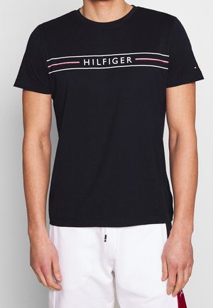 Schwarzes Baumwoll-T-Shirt mit Rundhalsausschnitt und einem weißen und roten "HILFIGER"-Logo auf der Brust, kurzen Ärmeln und lockerem Schnitt.