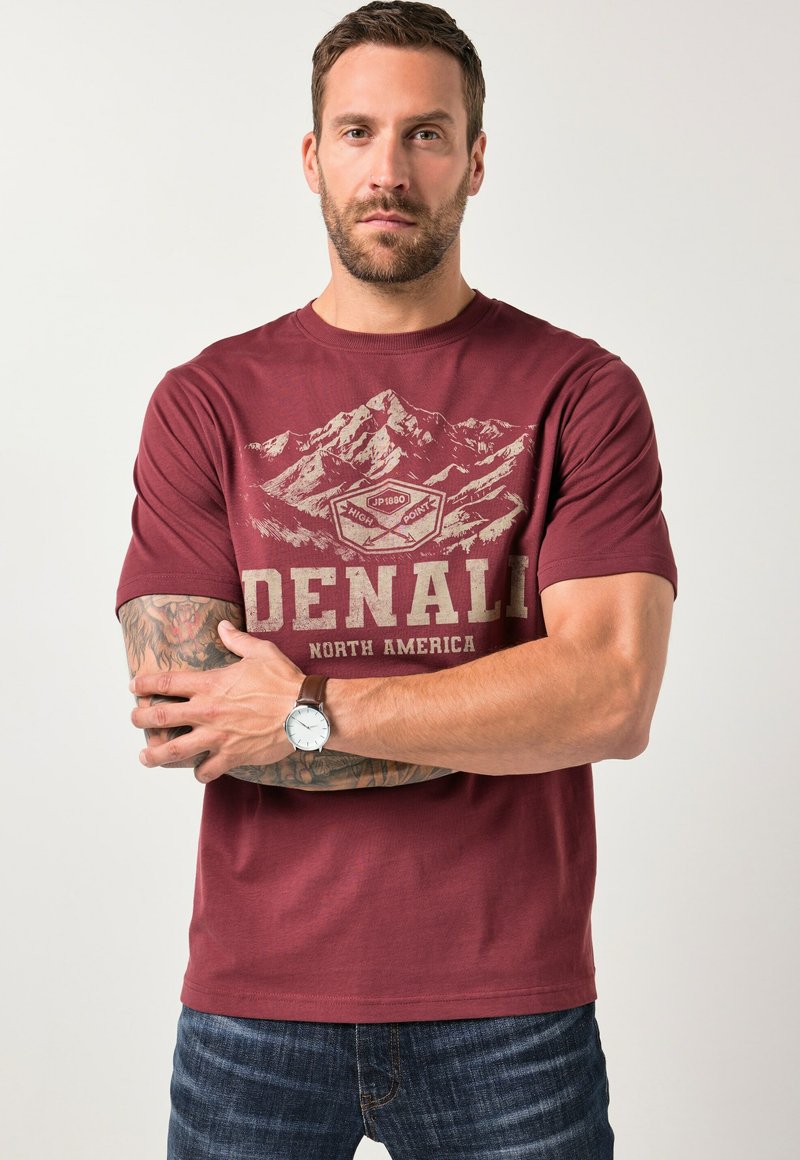 Bordo tričko s grafikou hory a textem "DENALI NORTH AMERICA". Krátké rukávy, kulatý výstřih a měkká textura s volným střihem.