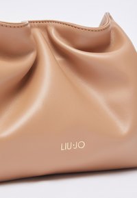 Beige leren handtas met geplooid ontwerp, een gladde textuur en een gouden "LIU·JO"-logo. Afgeronde vorm met zachte, vallende plooien.