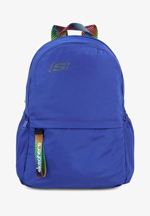 Mochila de tela azul con una superficie texturada, bolsillo frontal con cremallera y asa de rayas multicolor. Incluye el logo de Skechers en la parte frontal.