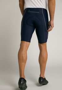 Shorts de vélo navy en tissu extensible, avec une zone de siège rembourrée, des accents réfléchissants et une poche zippée à l'arrière.