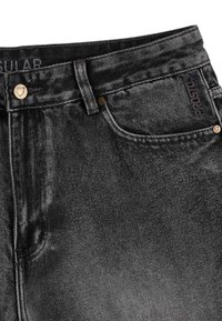 Czerny dżinsy o klasycznym pięciopocketowym designie, metalowych akcesoriach i subtelnym teksturowanym wykończeniu. Logo marki umieszczone na przedniej kieszeni.