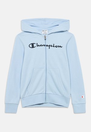 Jasnoniebieska bluza z kapturem na zamek, z przednimi kieszeniami, kapturem, czarnym napisem „Champion” na piersi oraz małym logo na mankiecie lewej rękawa.