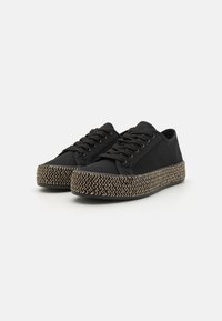 Sneaker neri in tela con una zeppa in juta intrecciata. Presentano un design con lacci e una suola piatta in gomma. Forma semplice e slanciata.