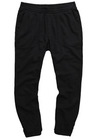 Czarne spodnie dresowe z miękkiego materiału, z elastycznym pasem, dwoma bocznymi kieszeniami i zwężanymi nogawkami.