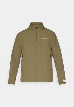 Olivgrüne Zip-Jacke mit hohem Kragen, zwei Seitentaschen und kleinem Logo auf der Brust. Glattes Material mit leicht matter Textur.