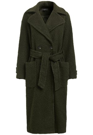 Manteau long en laine texturée vert foncé avec larges revers, boutons croisés, grandes poches avant et ceinture à nouer à la taille.
