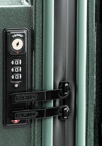 Verriegelungsmechanismus an einem dunkelgrünen Koffer mit einem Zahlenschloss, Schlüsselschlitz und schwarzen Metallverschlüssen mit Branding. Strukturierte Oberflächendetails.