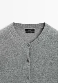 Cardigan in cashmere grigio chiaro con scollatura rotonda e tre bottoni visibili, etichettato Massimo Dutti, prodotto in Cina.