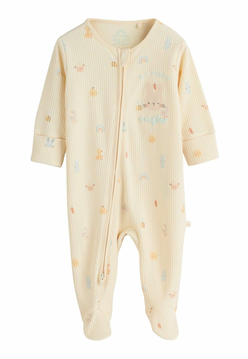 Dzeltens bērnu kombinezons ar gariem piedurknēm un rāvējslēdzēju priekšpusē, dekorēts ar pasteļtoņu dzīvnieku un varavīksnes ilustrācijām, kā arī ar uzrakstu "Mans pirmais Lieldienas".