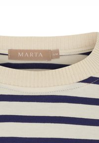 Beige T-shirt med marineblå horisontale striber, med en ribbet rund hals og en label med teksten "MARTA S/M" nær halsudskæringen.