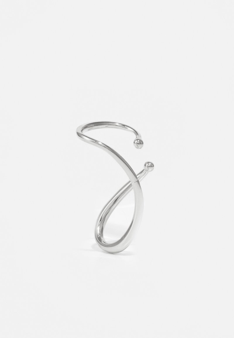 Ezüst, csavart pántú karkötő sima felülettel és két gömb alakú díszítéssel mindkét végén. A dizájn minimalista és szoborszerű.