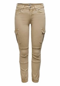 Pantalones cargo beige hechos de suave algodón. Presentan múltiples bolsillos laterales, un diseño ajustado en los tobillos y un estilo clásico de cinco bolsillos.