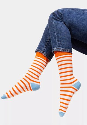 Skarpetki w paski z pomarańczowymi i białymi paskami, z jasnoniebieskimi akcentami na pięcie i palcach, o długości do połowy łydki, wykonane z miękkiego materiału.
