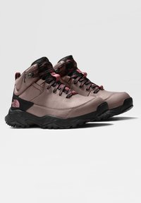 Stivali da trekking alti in morbido materiale sintetico rosa con suole in gomma nera, punte arrotondate e lacci rosa/neri. Presentano il logo sul tallone.