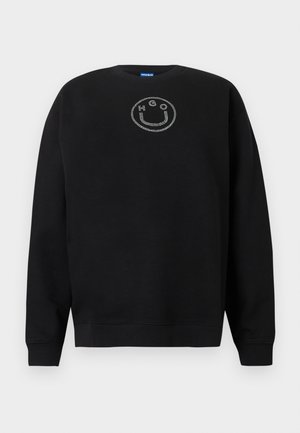 Svart genser laget av bomullsblanding, med rund hals, lange ermer og en smilefjeslogo av rhinestones på brystet.