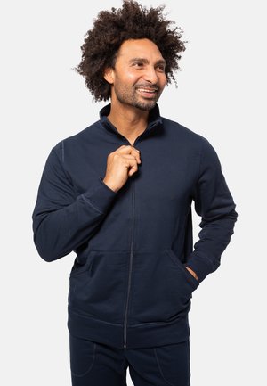 Marineblauwe zip-up hoodie met een hoge kraag, voorzakken en een gladde textuur. Ideaal voor casual dragen met een aansluitende pasvorm.