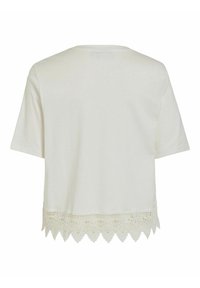 Camiseta blanca de manga corta con dobladillo de encaje en forma de concha, hecha de algodón suave. Presenta un escote redondo y un corte relajado.