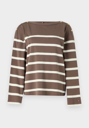 Maglia marrone a maniche lunghe con strisce orizzontali bianche, bottoni dorati sulle spalle e un piccolo logo vicino al polsino del maniche sinistra.
