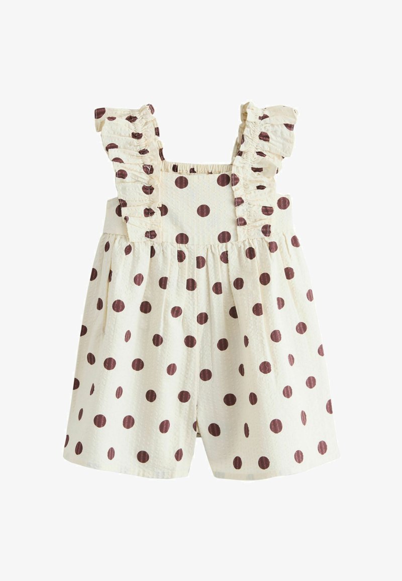 Combinaison pour tout-petit de couleur crème avec des pois marron, des bretelles à volants et une taille froncée.