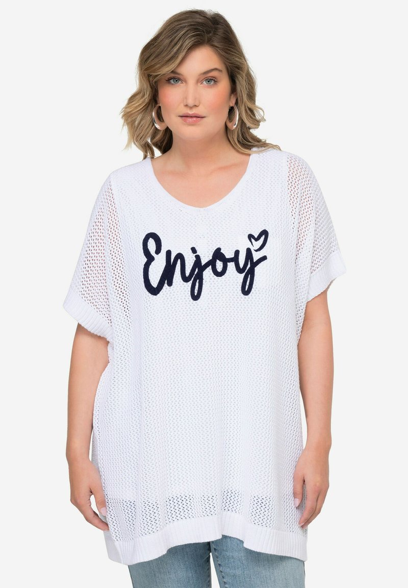 Top oversize de malla blanca con escote en forma de V. Presenta la palabra "Enjoy" en letras marinas, mangas cortas y un corte holgado. Textura suave, diseño casual.