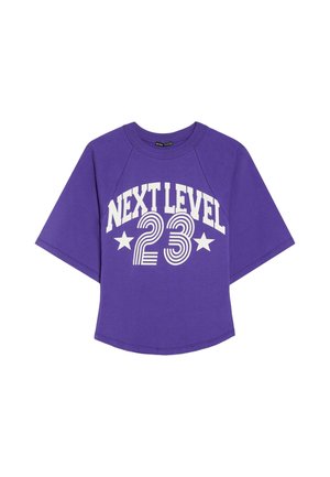 Fialové tričko s krátkym rukávom s bielym textom "NEXT LEVEL 23" a dvoma hviezdami, navrhnuté s voľným strihom a okrúhlym výstrihom.