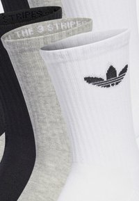 Baumwollmischungssocken in Schwarz, Grau und Weiß; gerippte Textur; mit Adidas-Logo auf der weißen Socke; 3-Streifen-Detail am Bündchen.